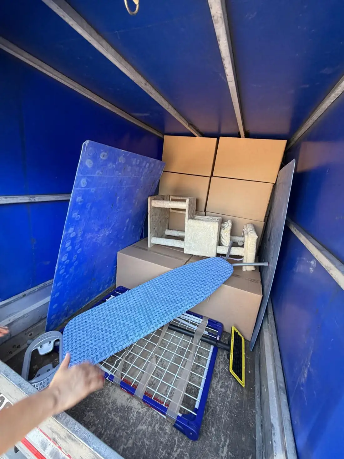 Wnętrze busa FastMove z równo ułożonymi kartonami i zabezpieczonym materacem