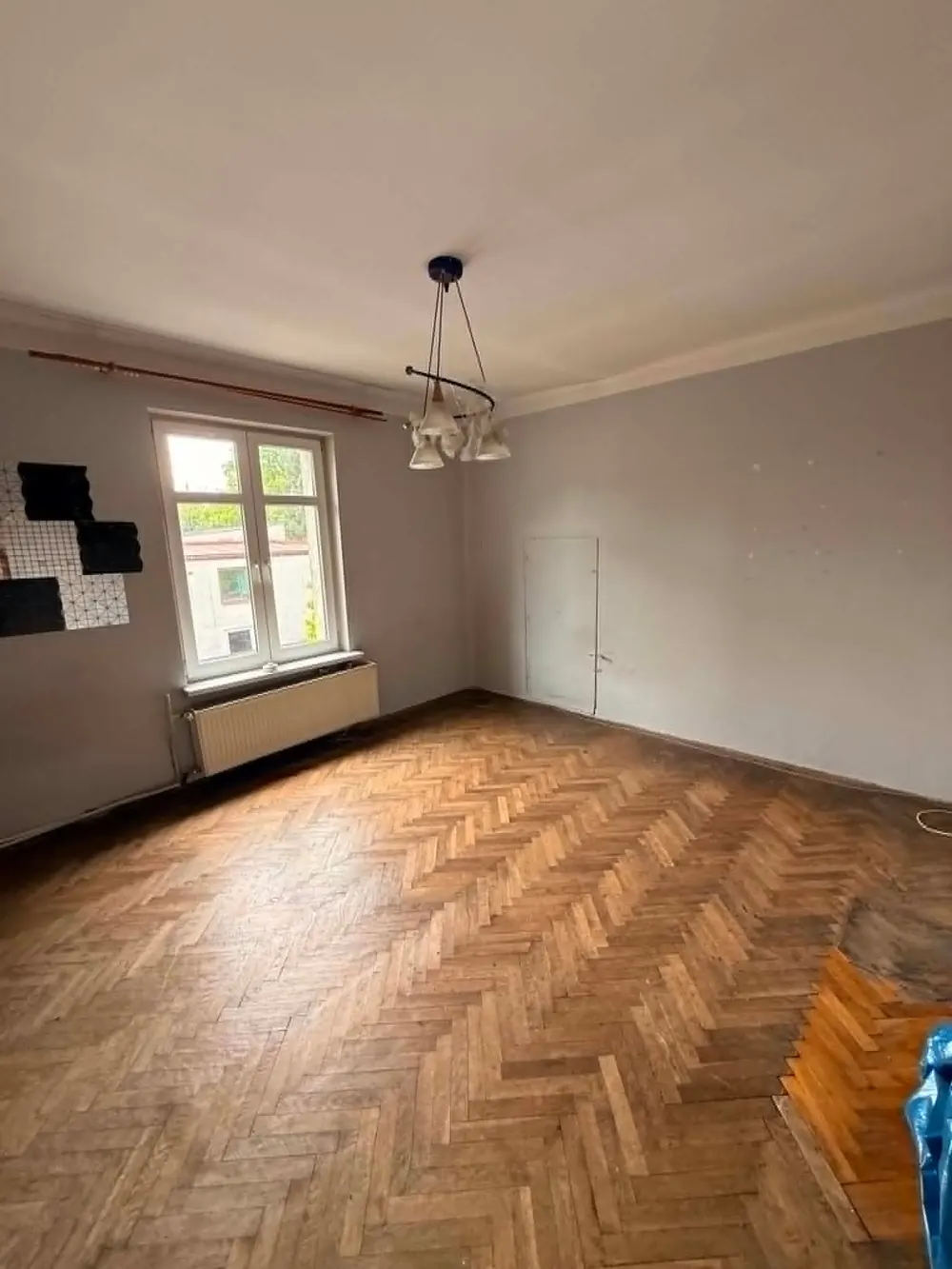 Ten sam pokój po opróżnieniu, pusty parkiet i wolna przestrzeń