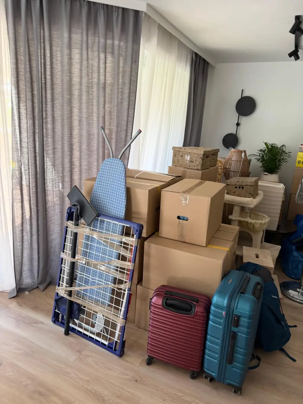 Pokój ze spakowanymi kartonami, walizkami i suszarką przygotowanymi do przewozu
